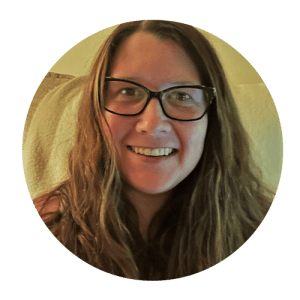 a person wearing glasses and smiling at the camera