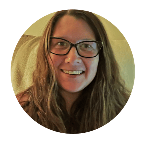 a person wearing glasses and smiling at the camera